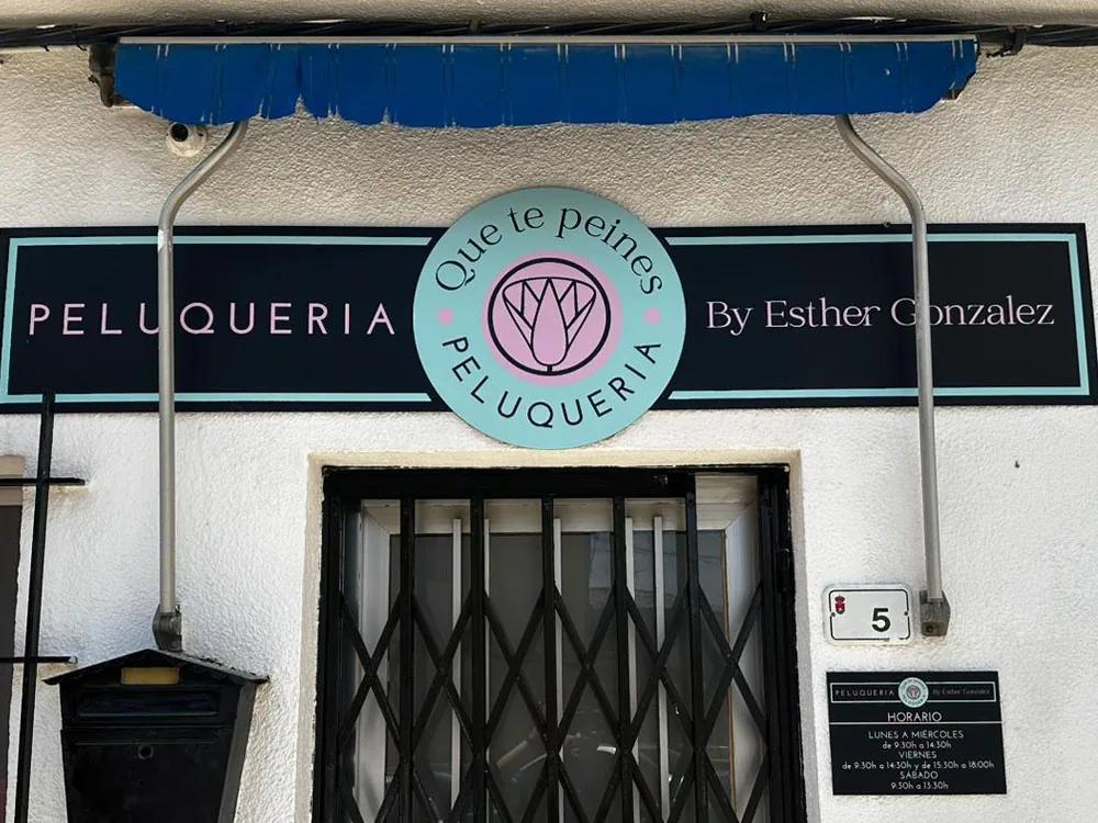 Rótulo de fachada de la peluquería Que te Peines en dibond decorado con vinilo impreso
