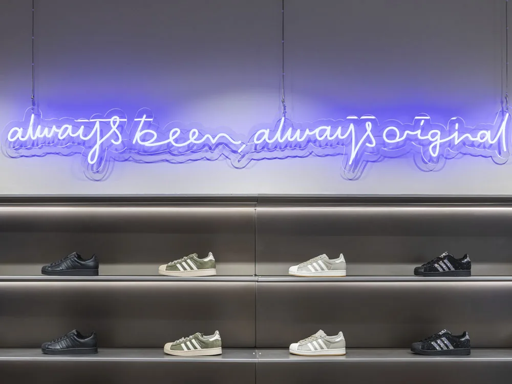 Rótulo de neón flex azul «always been, always original» suspendido del techo en tienda