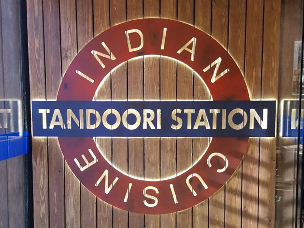 Rótulo retroiluminado del restaurante Tandoori Station Indian Cuisine en aluminio envejecido