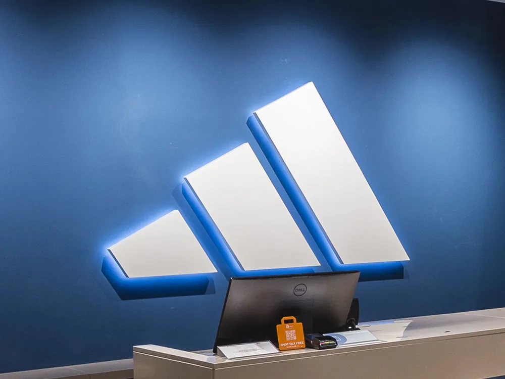 Logotipo Adidas retroiluminado de aluminio lacado con luz fría en recepción