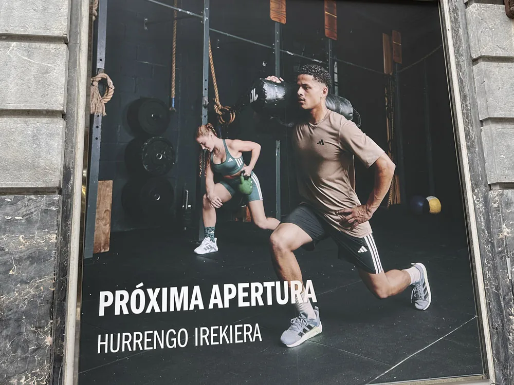 Vinilo promocional de Adidas con deportistas en escaparate por próxima apertura
